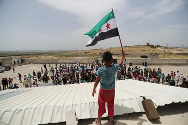 A boy waves a Free Syrian army flag during a protest at the Atmeh crossing on the Syrian-Turkish border, in Idlib governorate, on May 31, 2019. Reuters