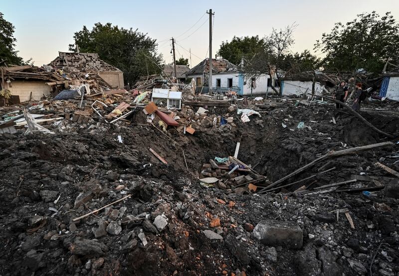People stand on the rubble of a house destroyed by a Russian military strike in Chaplyne, Dnipropetrovsk region, Ukraine. Reuters