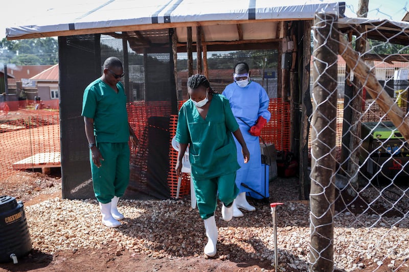 An attendant disinfects the  boots of a medical officer before leaving the Ebola isolation section of Mubende Regional Referral Hospital, in Mubende, Uganda. September 29, 2022. AP