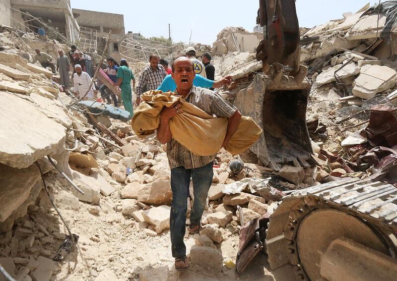 A Syrian man carries a body after it was removed from the rubble of buildings following a reported barrel bomb attack by government forces on the Qadi Askar district of the northern Syrian city of Aleppo on May 20, 2015. The civil war in the country has claimed more than 220,000 lives since the conflict began in March 2011. Zein Al Rifai/AFP Photo