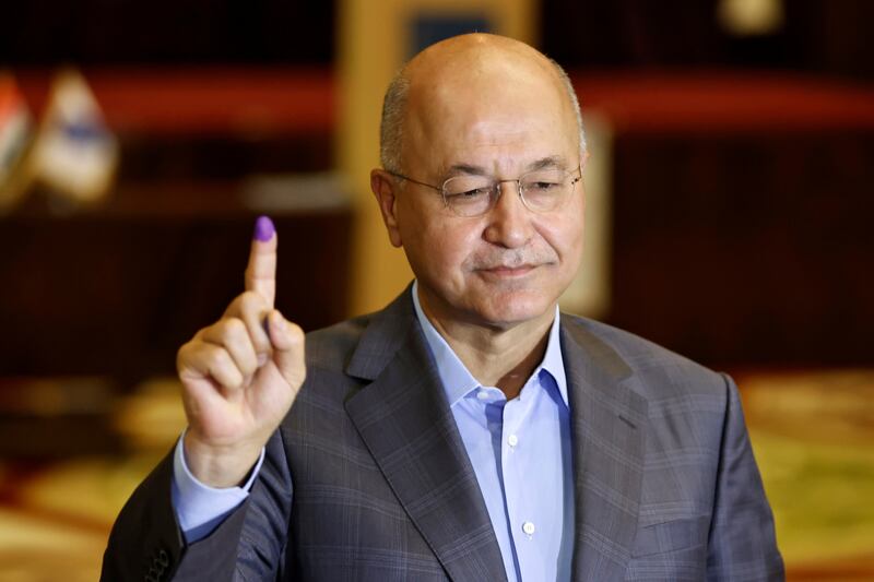 Iraq's President Barham Salih shows his inked finger at a polling station in Baghdad, in the parliamentary election in October 2021. Reuters