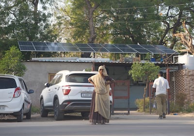 A woman stands next to solar power panels installed at a government building in Modhera in western Gujarat. The village is India’s first solar powered village. Taniya Dutta/ The National