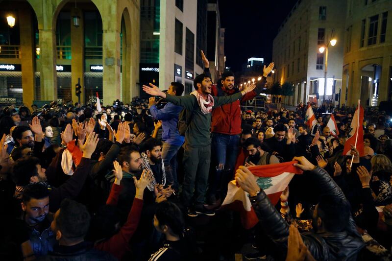 Protesters chant slogans during ongoing demonstrations against the Lebanese political class, as riot police block a road leading to the parliament building in Beirut. AP Photo