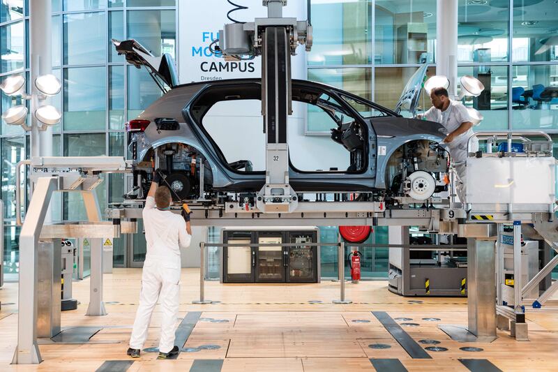 Employees assemble a Volkswagen electric car. AFP