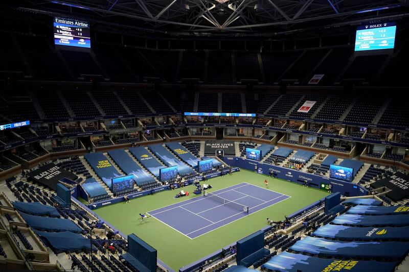 Stands at Arthur Ashe Stadium sit nearly empty as Novak Djokovic, of Serbia, left, returns to Damir Dzumhur, of Bosnia and Herzegovina, during the first round of the US Open tennis championships, in New York. AP Photo