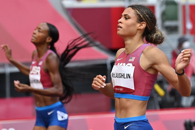 USA's Sydney Mclaughlin reacts as she crosses the finish line past USA's Dalilah Muhammad.