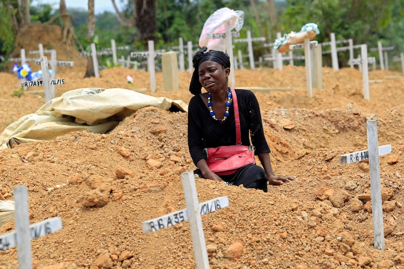 epa05203587 A woman mourns at her father's grave at Disco Hill Safe Burial Site, in Margibi County, Liberia, 09 March 2016. Decoration Day or Memorial Day is observed on the second Wednesday of March in Liberia, 09 March 2016 for the current year, to honor and remember the dead.  EPA/AHMED JALLANZO