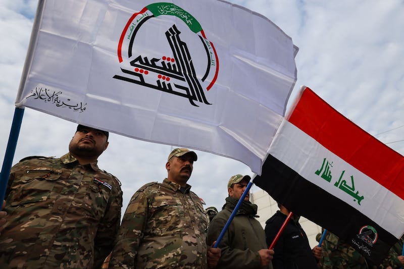 Members of Iraq's Hashd Al Shaabi carry flags ahead of the funeral of people killed in US strikes in western Iraq. AFP