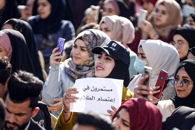 A protester holds up a sign reading in Arabic "the student sit-in continues".  AFP