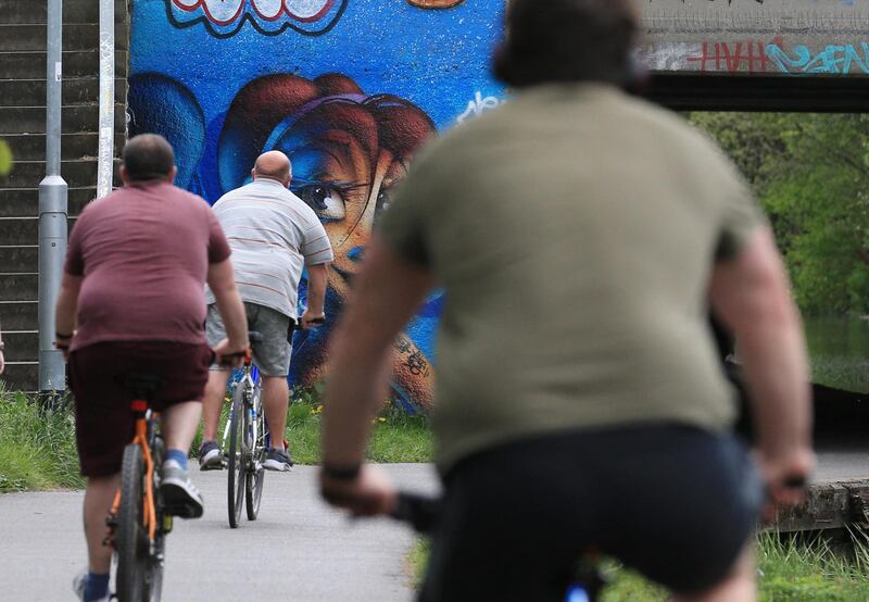 People take their daily exercise along the Leeds to Liverpool canal in Leeds, northern England on May 2, 2020, during the nationwide lockdown to curb the novel coronavirus COVID-19 pandemic. - Britain's overall death toll from the coronavirus outbreak rose by 739 to 27,510 on Friday, as new data indicated that people in disadvantaged areas were worse hit. (Photo by Lindsey Parnaby / AFP)