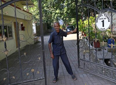 Prabhu Dayal, a 75-year-old watchman, opens the gate for a resident at a housing society in Mumbai, India, November 12, 2015. To match Special Report INDIA-MEDICINE/ABBOTT  REUTERS/Danish Siddiqui
