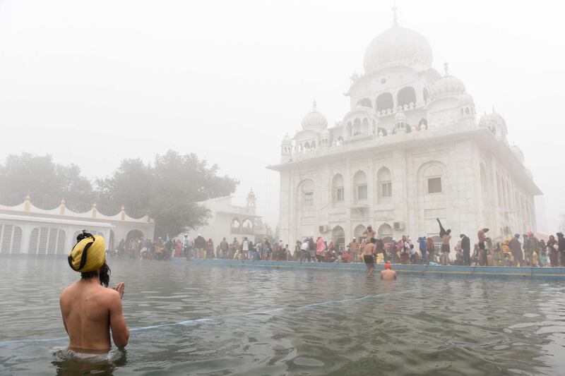 A man takes a dip in the Sarovar, or water tank, during Basant Panchami celebrations at the Sikh Shrine Gurudwara Chheharta Sahib on the outskirts of Amritsar, India. AFP