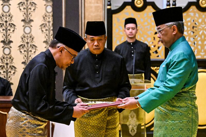 Malaysia's King Sultan Abdullah Sultan Ahmad Shah, right, and newly appointed Prime Minister Anwar Ibrahim, left, take part in the swearing-in ceremony at the National Palace in Kuala Lumpur, Malaysia. AP