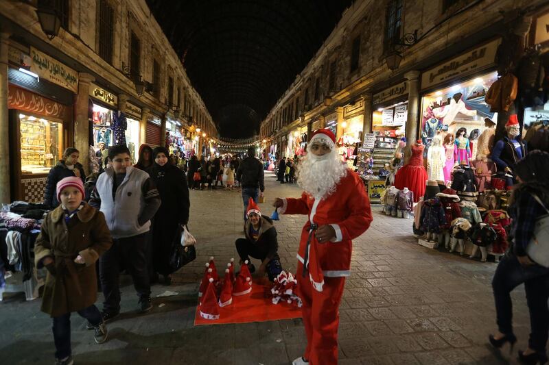 epa06405006 A Syrian is dressed in Santa Claus clothes is seen at al-Hamidiyeh old souk in Damascus, Syria, 24 December 2017.  Prior to the current conflict, Christians are believed to have made around ten per cent of the 23 million Syrian population.  EPA/YOUSSEF BADAWI