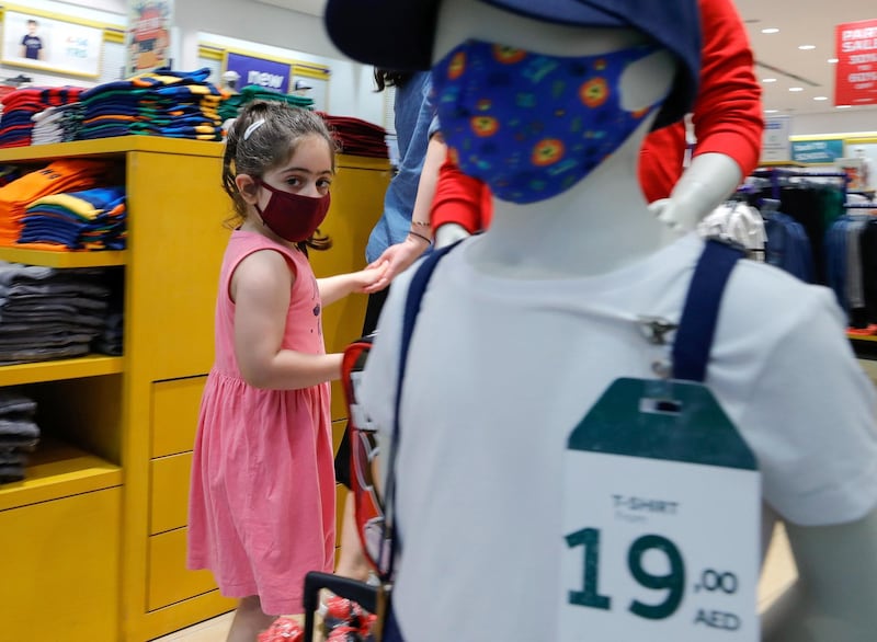 Abu Dhabi, United Arab Emirates, August 23, 2020.   A girl with a face mask on passes a mannequin promoting face mask sales at the LC Waikiki shop in Al Wahda Mall, Abu Dhabi.Victor Besa /The NationalSection:  NAReporter: