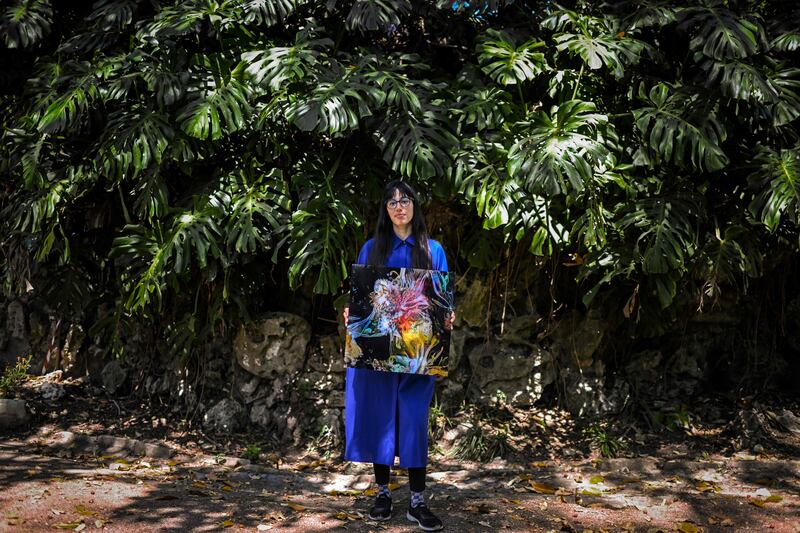 Argentine artist Sofia Crespo holds one of her works as she poses for a photo at the Estrela garden in Lisbon on June 8, 2022. AFP