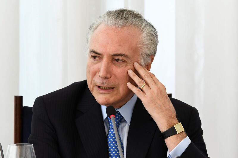 Brazilian President Michel Temer speaks during a breakfast with journalists accredited to the presidency, at Alvorada Palace in Brasilia on December 22, 2017. 
Temer said that foreign capital is welcome at Embraer, but that the government is not considering giving up control of the Brazilian aircraft manufacturer. US aerospace giant Boeing and Embraer confirmed Thursday that they have held talks about a potential tie-up, but stated that there was no guarantee that any deal would result from the discussions, as it would depend on approval by the Brazilian government. / AFP PHOTO / EVARISTO SA