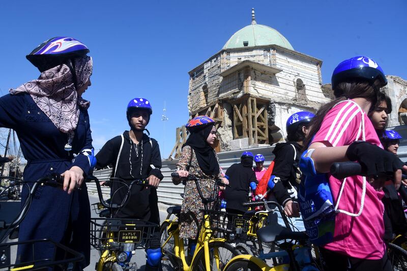 Cyclists gather for the first all-female Mosul race near the Great Mosque of Al Nuri. The Mosul landmark was damaged during the occupation by ISIS. EPA