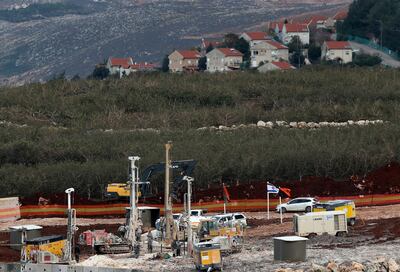 In this Thursday, Dec. 13, 2018 photo, Israeli military equipment works on the Lebanese-Israeli border in front of the Israeli town of Metula, background, near the southern village of Kafr Kila, Lebanon. As Israeli excavators dig into the rocky ground, Lebanese across the frontier gather to watch what Israel calls the Northern Shield operation aimed at destroying attack tunnels built by Hezbollah. But Lebanese soldiers in new camouflaged posts, behind sandbags, or inside abandoned homes underscore the real anxiety that any misstep could lead to a conflagration between the two enemy states that no one seems to want. (AP Photo/Hussein Malla)