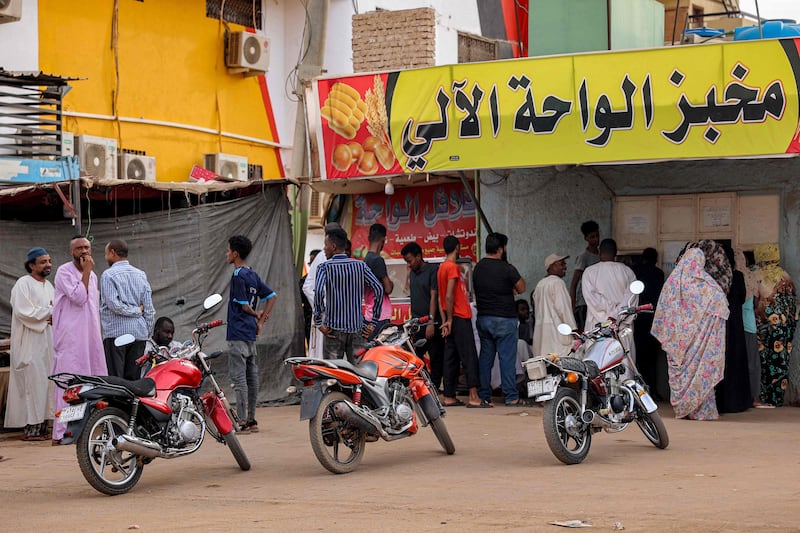People queue for bread outside a bakery amid a food crisis in Khartoum. AFP