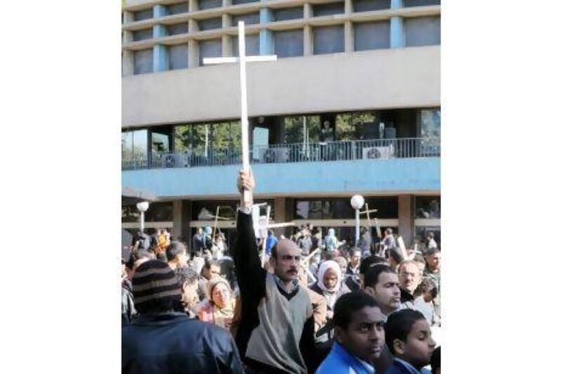 An Egyptian Christian holds a cross during a protest in front of the Information centre building in Cairo over the burning of a church in the Cairo suburbs.