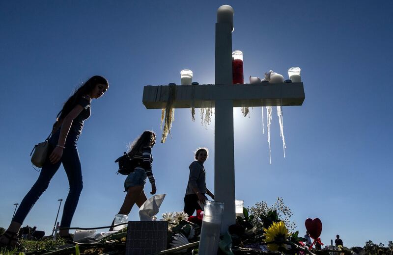 epa06533928 People visit the temporary memorial a day after candlelight vigil at the Amphitheater at Pine Trails Park, Parkland, Florida, USA, 16 February 2018. The vigil honors victims of a mass shooting that took place at Marjory Stoneman Douglas High School on 14 February that left 17 dead. Nikolas Jacob Cruz, reportedly an expelled student, has been charged with seventeen counts of premeditated murder in the shooting at Marjory Stoneman Douglas High School in Parkland, Florida on 14 February 2018.  EPA/CRISTOBAL HERRERA