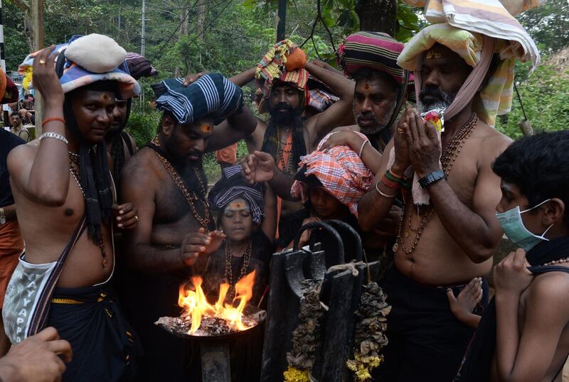 This photo taken on November 18, 2018 shows Indian Hindu devotees offering prayers at the start of the trek to the Sabarimala temple in the southern state of Kerala. Tens of thousands of pilgrims have thronged to the hilltop shrine ahead of a Supreme Court ruling November 19 on whether it should be given more time to let women enter. The Sabarimala temple in the southern state of Kerala has become a major battleground between Hindu radicals and gender activists. / AFP / Arun SANKAR
