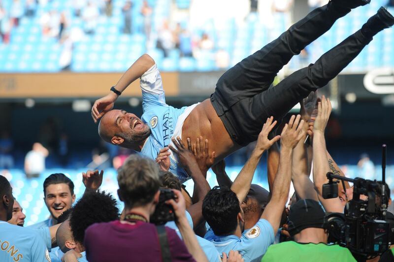 Manchester City players and staff throw manager Pep Guardiola in the air. Rui Vieira / AP Photo