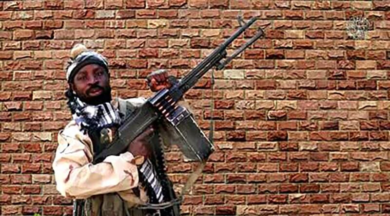 (FILES) This file screengrab made on January 15, 2018, from a video released the same day by Islamist militant group Boko Haram shows Boko Haram factional leader Abubakar Shekau holding a heavy machine gun at an undisclosed location in Nigeria.  Nigerian Boko Haram leader Abubakar Shekau has been seriously wounded after trying to kill himself to avoid capture during clashes with rival Islamic State-allied jihadists in the north of the country, two intelligence sources said May 20, 2021. Shekau's Boko Haram faction and fighters from the Islamic State West Africa Province had been battling in northeastern Borno state, where ISWAP militants have become the dominant force in Nigeria's more than decade-long jihadist insurgency. Shekau, who made international headlines when his men kidnapped nearly 300 schoolgirls in Chibok in 2014, has been reported dead several times since Boko Haram first began its insurgency in 2009.
 - RESTRICTED TO EDITORIAL USE - MANDATORY CREDIT "AFP PHOTO / BOKO HARAM" - NO MARKETING NO ADVERTISING CAMPAIGNS - DISTRIBUTED AS A SERVICE TO CLIENTS


 / AFP / BOKO HARAM / Handout / RESTRICTED TO EDITORIAL USE - MANDATORY CREDIT "AFP PHOTO / BOKO HARAM" - NO MARKETING NO ADVERTISING CAMPAIGNS - DISTRIBUTED AS A SERVICE TO CLIENTS


