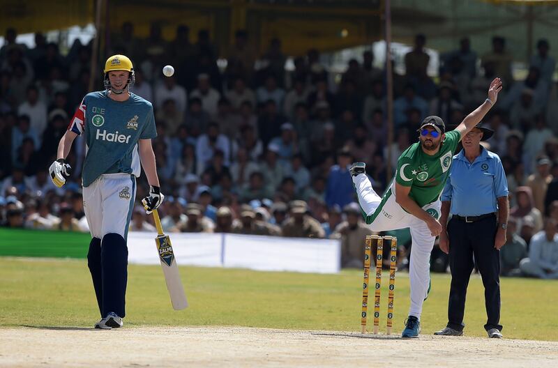 Pakistan XI bowler Shahid Afridi (R) delivers the ball next to UK Media XI batsman during a T20 cricket match between Pakistan XI and UK Media XI at the Younis Khan Cricket Stadium in Miranshah, the former stronghold of Al-Qaeda and Taliban militants, in North Waziristan near the Afghan border on September 21, 2017.
Thousands of cricket fans cheered on their favourite stars and waved signs proclaiming: "We want peace" as players competed in an international T20 Thursday in the former Taliban stronghold of Miranshah that authorities proudly showcased as free of militants. / AFP PHOTO / AAMIR QURESHI