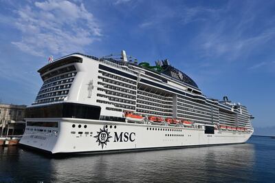 A picture taken in the northern Italian port of Genoa on August 16, 2020 shows the MSC Grandiosa cruise liner leaving the port pulled by a little boat after six-and-half months of inactivity due to the novel coronavirus, COVID-19, pandemic. The first major cruise ship to set sail in the Mediterranean was poised to depart from Genoa as Italy's struggling travel industry hopes to regain ground after a bruising coronavirus hiatus, representing a high-stakes test for the global sector in the key Mediterranean market and beyond.  / AFP / MIGUEL MEDINA
