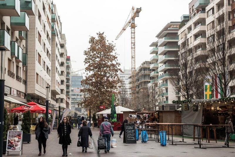 Pedestrians walk by completed and under-construction residential apartments in the Corvin project, a development by the Futureal Group, in Budapest, Hungary, on Thursday, Dec. 17, 2015. The Hungarian government has published a draft law cutting value-added tax on new home construction from 27% to 5% in 2016. Photographer: Akos Stiller/Bloomberg