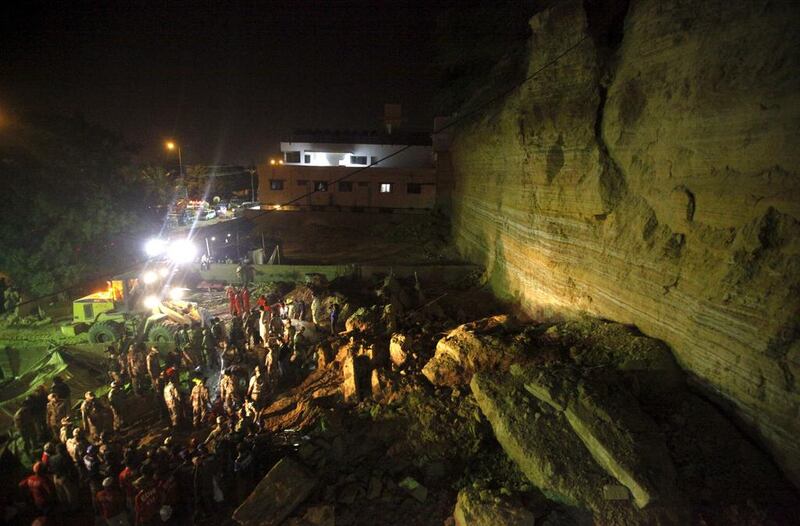 Rescue workers and paramilitary forces search for survivors in the rubble of a landslide in the Gulistan-i-Jauhar area in Karachi. Athar Hussain / Reuters