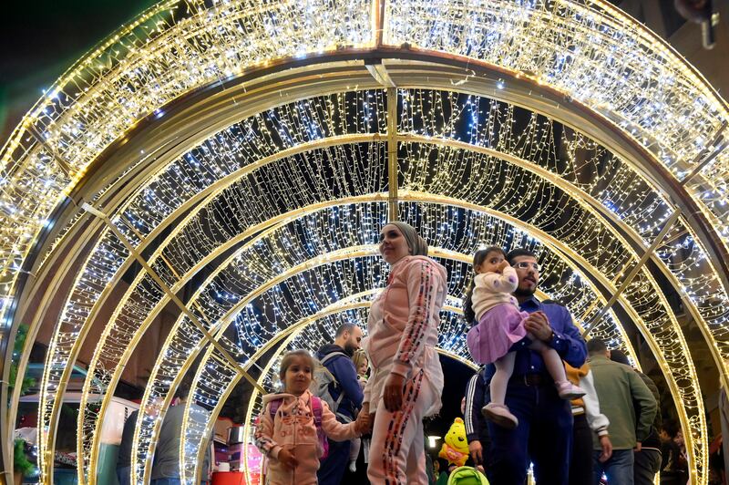 Visitors admire seasonal illuminations to celebrate Christmas and New Year in the Beirut Souks district of Lebanon's capital. EPA