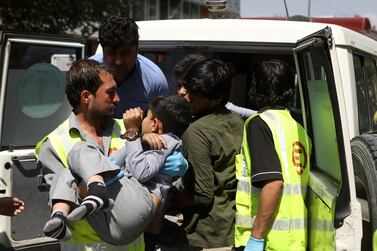 An Afghan health worker carries a wounded school student after a car bomb blast targeted a governmental building. EPA