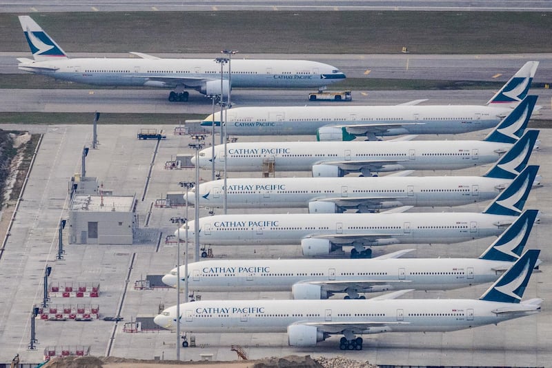 A Cathay Pacific passenger airplane (top) is taxied onto the runway as other aircrafts belonging to the local flagship carrier are seen parked on the tarmac at Hong Kong's Chek Lap Kok International Airport on March 10, 2020. - Hong Kong's flagship carrier Cathay Pacific is expected to release its full-year financial results on March 11. (Photo by Anthony WALLACE / AFP)