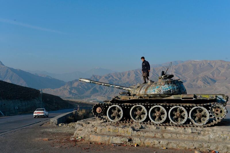 TOPSHOT - This photo taken on November 28, 2019 shows an Afghan boy playing on the wreckage of a Soviet-era tank alongside a road on the outskirts of Kabul. December 2019 marks the 40th anniversary of the Soviet Union's "intervention" -- or invasion -- of Afghanistan. In the decades since the war, which ended in 1989, Afghan veterans like Shah Sulaiman and former Soviet soldiers have had to grapple with the physical and emotional wounds of a bloody conflict whose purpose and consequences remain angrily contested. - TO GO WITH 'AFGHANISTAN-CONFLICT-USSR-RUSSIA-ANNIVERSARY',FOCUS BY MUSHTAQ MOJADDIDI and MARINA LAPENKOVA
 / AFP / NOORULLAH SHIRZADA / TO GO WITH 'AFGHANISTAN-CONFLICT-USSR-RUSSIA-ANNIVERSARY',FOCUS BY MUSHTAQ MOJADDIDI and MARINA LAPENKOVA
