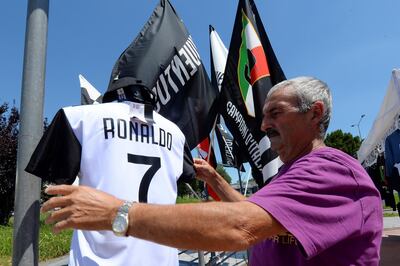 A vendor adjusts a Juventus' jerseys with the name of Cristiano Ronaldo exhibited in his shop in Turin, Italy July 7, 2018. REUTERS/Massimo Pinca