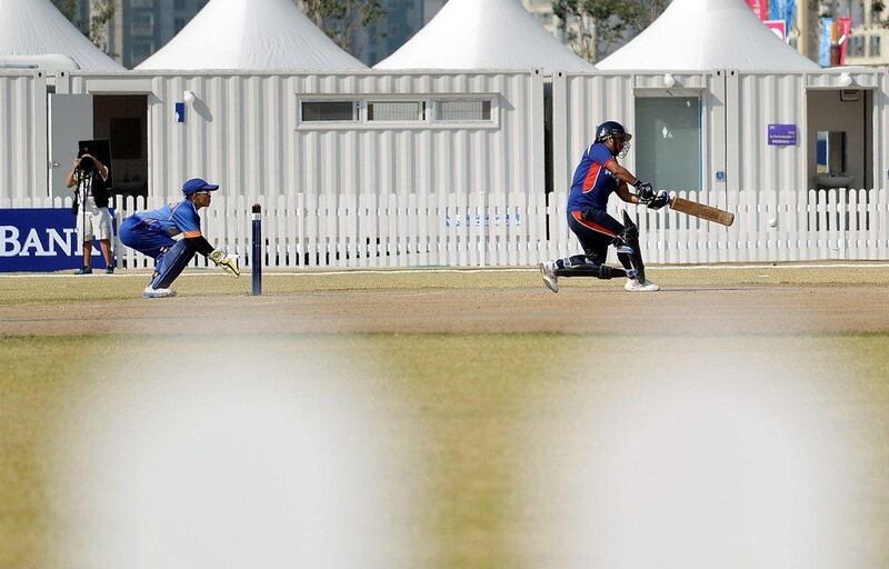 Nepal's Sita Rana Magar plays a shot as Malaysia's wicketkeeper Christina Baret, left, looks on during their women's cricket group match at the 2014 Asian Games. Manan Vatsyayana / AFP