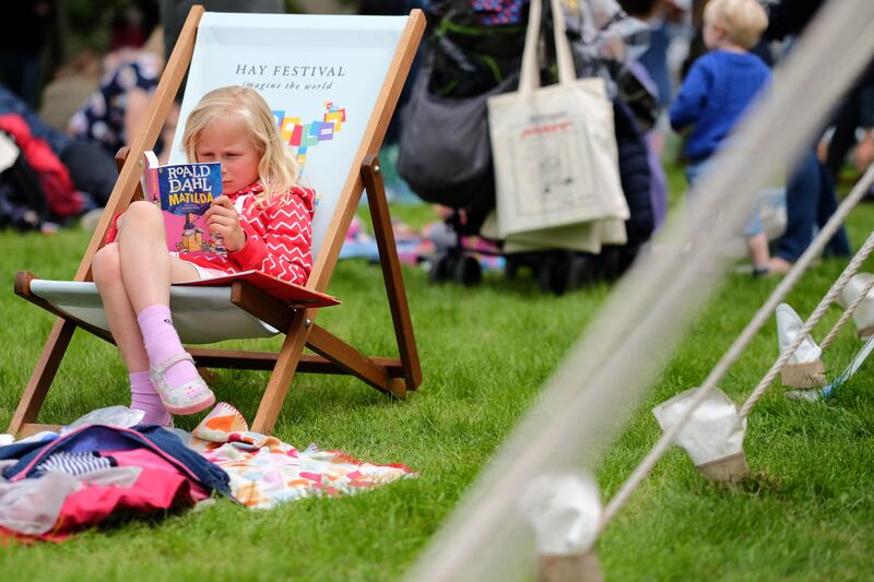 A young girl reads 'Matilda' by Roald Dahl. Dahl's books have been translated into 63 languages and sold more than 300 million copies worldwide. Alamy