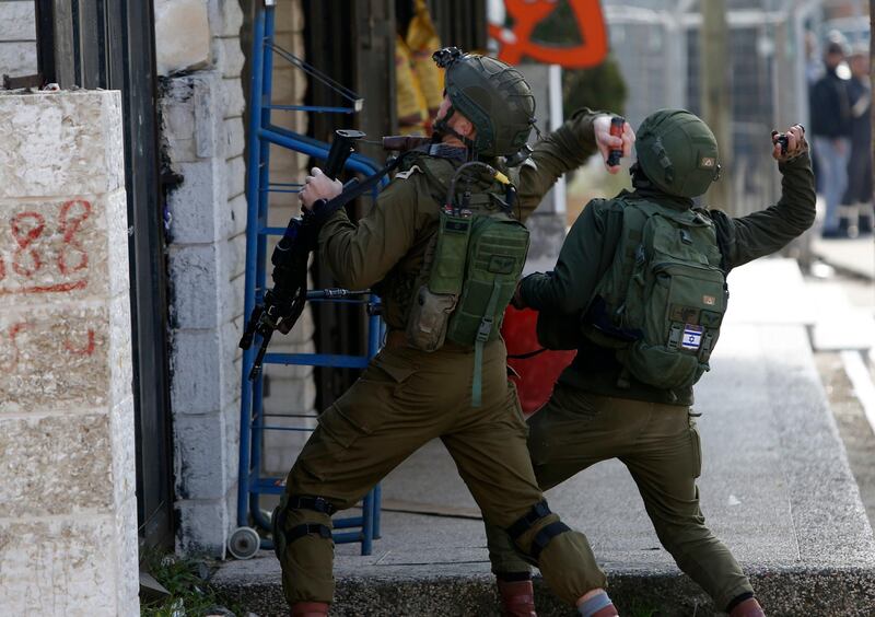 Israeli soldiers throw sound bombs as they clash with Palestinians during a search for suspects of a shooting attack yesterday in the West Bank City of Ramallah, Monday, Dec. 10, 2018. Israeli officials say seven people have been wounded, one critically, in a shooting by a suspected Palestinian assailant outside a Jewish settlement of Ofra in the West Bank. (AP Photo/Majdi Mohammed)