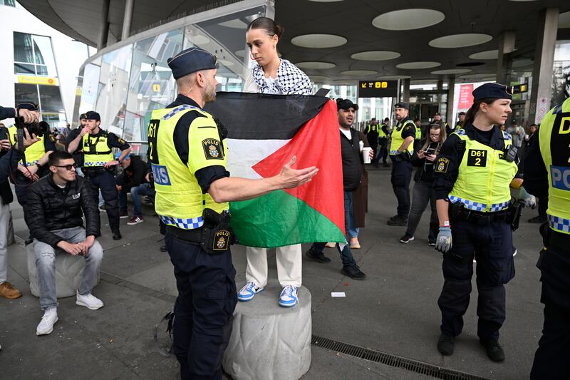 A police officer talks to a demonstrator at a pro-Palestine rally against the participation of Israel in the 68th Eurovision Song Contest in Malmo. EPA