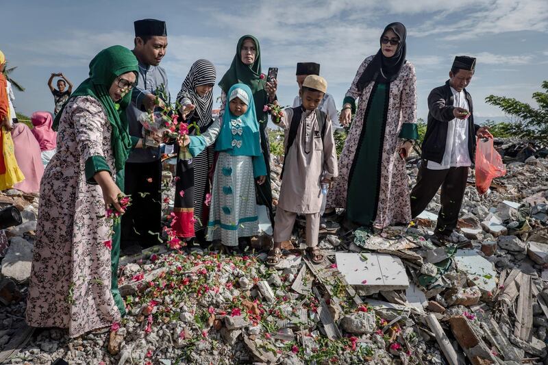 People take a part in mass prayer among ruins of damaged houses in Balaroa village, as Indonesians mark one year since the Palu earthquake in Central Sulawesi, Indonesia. According the Red Cross, Almost 60,000 people continue to be left homeless a year after the devastating earthquake and tsunami .  Getty