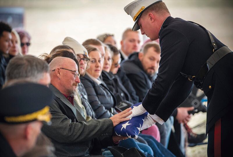 Jim McCollum is presented with the American flag at a memorial service for his son, Lance Cpl Rylee McCollum who was killed in a suicide bombing in Afghanistan in August 2021. AP