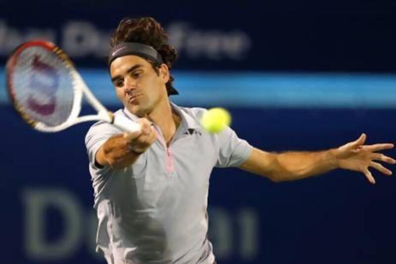 Roger Federer of Switzerland hits a return to Malek Jaziri of Tunisia during their men's singles match at the ATP Dubai Tennis Championships, February 25, 2013. REUTERS/Mohammed Salem (UNITED ARAB EMIRATES - Tags: SPORT TENNIS) *** Local Caption *** DUB16_TENNIS-MEN-DU_0225_11.JPG