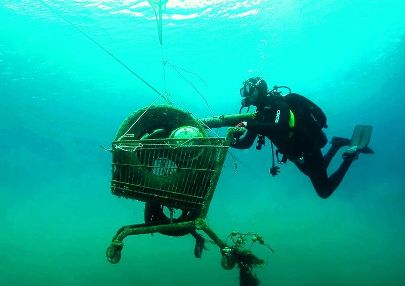 Volunteers collect a rusted shopping cart from the sea near the Ionian island of Zakynthos, during an operation to protect Aegean biodiversity from waste.  AFP