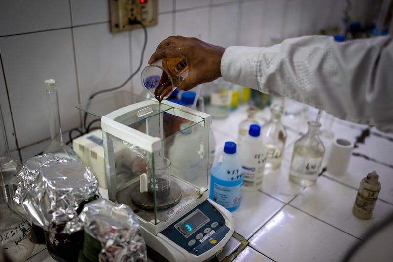 A lab technician analyses molasses, a main ingredient in making of ethanol, inside a laboratory at Bajaj Hindustan Sugar factory in Meerut, India. AP