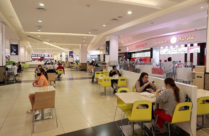 DUBAI, UNITED ARAB EMIRATES , April 29 – 2020 :- People having food inside the food court at Mall of the Emirates. Authorities ease the restriction for the residents in Dubai. At present mall opening timing is 12:00 pm to 10:00 pm. Carrefour timing is 9:00 am to 10:00 pm. Barricades put up around the food court area during the Ramadan. (Pawan Singh / The National) For News/Standalone/Online. Story by Patrick