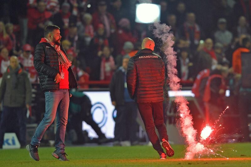 BERLIN, GERMANY - NOVEMBER 02: A firework lands on the pitch while  press spokesman Christian Arbeit (L) of Union gets frightened after the Bundesliga match between 1. FC Union Berlin and Hertha BSC at Stadion An der Alten Foersterei on November 02, 2019 in Berlin, Germany. (Photo by Thomas F. Starke/Bongarts/Getty Images)