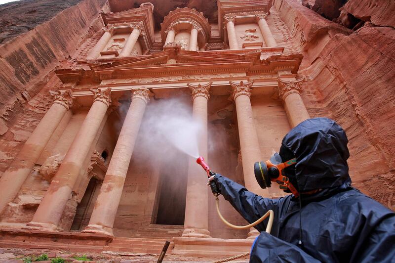 A labourer sprays disinfectant in Jordan's Petra south of the capital Amman to prevent the spread of coronavirus.   AFP
